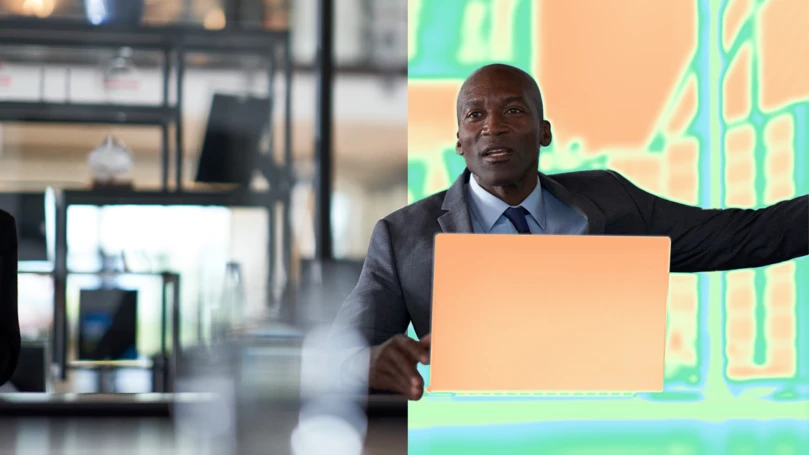 A man in a suit holding a laptop