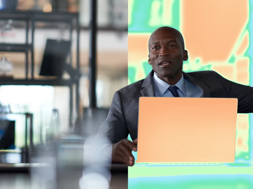 A man in a suit holding a laptop
